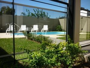 a view of a swimming pool with white chairs at Cuatro Estaciones in San José