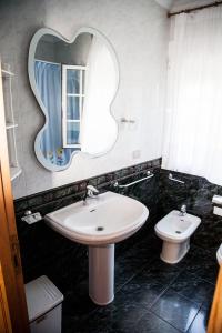 a bathroom with a sink and a mirror and a toilet at Casa Olga in Treacastela