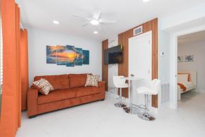 a living room with a brown couch and a bed at Clearwater Bliss Apartment 1 in Clearwater Beach