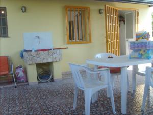 a room with a table and chairs and a fireplace at Villino Dodò in Torre San Giovanni Ugento