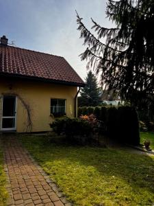 a house with a brick walkway in front of it at Domek Aga in Węgorzewo