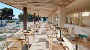 a restaurant with tables and chairs on a patio at Smy Portocolom in Portocolom +53 photos