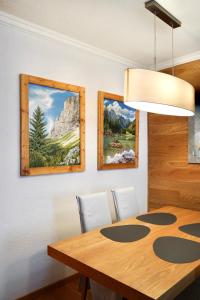 a dining room with a table and two paintings at Wilena Apartments in Villach