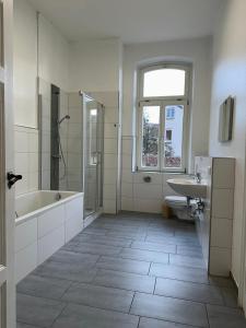 ein weißes Badezimmer mit Badewanne und Waschbecken in der Unterkunft Ferienwohnungen Neumann in Bamberg
