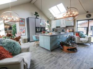 a kitchen and living room with blue cabinets and a island at Scotia At The Brig in Brydekirk