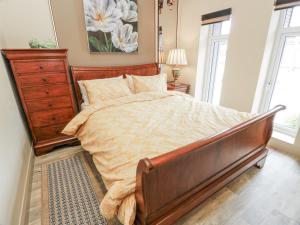 a bedroom with a large bed and a dresser at Scotia At The Brig in Brydekirk