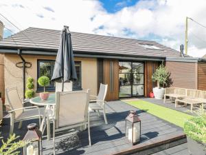 a patio with a table and an umbrella at Scotia At The Brig in Brydekirk
