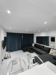 a living room with a black couch and chairs at North beach summer sands holiday in Durban