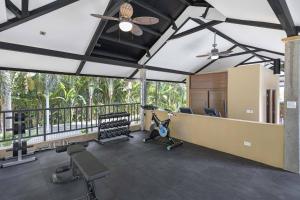 ein Raum mit einem Fitnessraum mit Stühlen und einem Deckenventilator in der Unterkunft Heavenly View - 2 BDRM Oceanview Apartment in Jacó