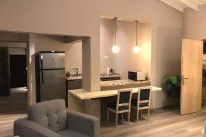 a kitchen with a refrigerator and a table and chairs at Apto BR Suites 6 min de Provenza, encanto natural in Medellín
