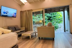 a living room with a couch and a tv at Apto BR Suites 6 min de Provenza, encanto natural in Medellín