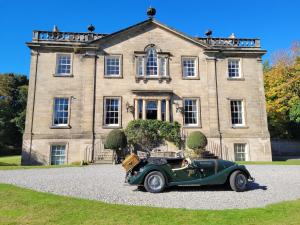 een oude groene auto geparkeerd voor een huis bij Dalvey House in Forres