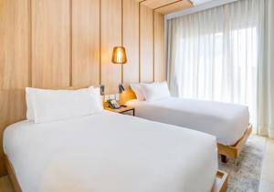 a hotel room with two beds and a window at Radisson Pinheiros in São Paulo