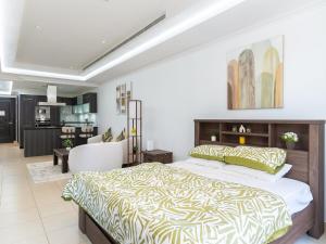 a bedroom with a large bed and a living room at Furnished Studio In The Pearl - FGR2 in Doha +14 photos
