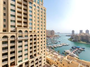 a view of a river between two tall buildings at Furnished Studio In The Pearl - FGR2 in Doha
