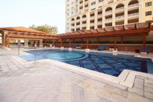 a swimming pool in front of a building at Furnished Studio In The Pearl - FGR2 in Doha