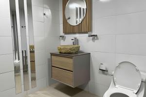 a bathroom with a toilet and a mirror at Apt Palos Altos Poblado, a distancia caminando de restaurantes in Medellín
