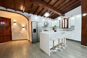 a kitchen with white cabinets and a counter with stools at Apt Palos Altos Poblado, a distancia caminando de restaurantes in Medellín