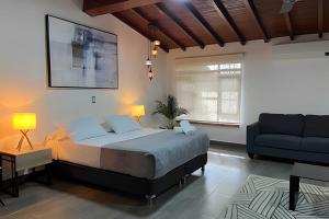 a bedroom with a large bed and a blue couch at Apt Palos Altos Poblado, a distancia caminando de restaurantes in Medellín