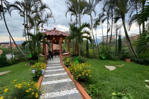 a garden with a gazebo and a pathway at Apt Palos Altos Poblado, a distancia caminando de restaurantes in Medellín