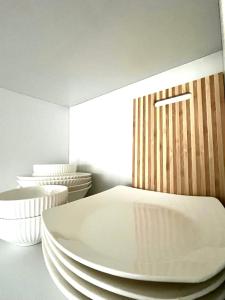 Ein Stapel weißer Teller lag auf einem Bett. in der Unterkunft Просторная 2-х комнатная квартира in Taras