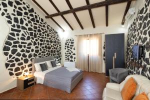 een slaapkamer met een bed en een bank erin bij Villa Jelù in Castiglione di Sicilia +23 foto's
