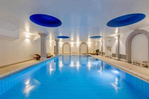 a large swimming pool with blue floors and ceilings at Greif Hotel & Spa in Trieste