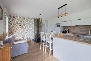 eine Küche und ein Wohnzimmer mit einer Couch und einem Tisch in der Unterkunft La petite maison dans la prairie in Néant-sur-Yvel