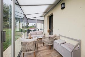 ein Wohnzimmer mit Couch und Stühlen in der Unterkunft La petite maison dans la prairie in Néant-sur-Yvel + 22 Fotos