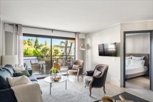 Vivre Cannes l Parking l Balcony l 15min to La Croisette في كان: غرفة فندق بها سرير وغرفة معيشة