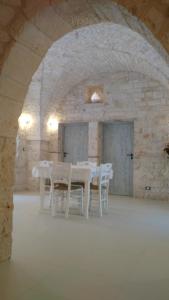 a dining room with white tables and white chairs at Dimora Sumerano in Alberobello