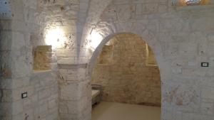 a room with an arch in a stone wall at Dimora Sumerano in Alberobello +37 photos