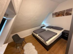 a small bedroom with a bed and a chair at Hel ændre men hyggelig lejlighed in Sønderborg