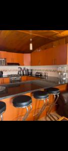 eine Küche mit einer Theke mit drei Barhockern in der Unterkunft Cozy Stayz in Hermanus