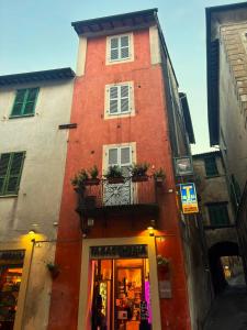a red building with a balcony on a street at Alloggio Turistico Sotto la Torre in Acquapendente