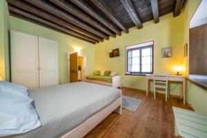 una camera da letto con un letto, una scrivania e una sedia di GuestHost - Antica Ferrovia Apartments Tarvisio a Tarvisio
