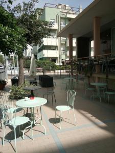 a patio with tables and chairs and a umbrella at Hotel Seaview in Rimini