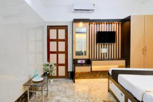 a hotel room with a bed and a tv at Super Hotel O Howrah Railway Station in Salkhia