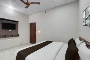 ジャイプールにあるCollection O Kesar Crossway Jaipur Formerly Laxmi Palaceのベッドと薄型テレビのある寝室