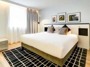 巴黎巴黎中心贝西诺富特酒店的卧室里有一张白色的大床和一扇窗户 更多99张照片