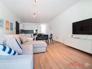 a living room with a couch and a dining room at Balcony Apartment in Charming Malta Village in Hal Ghaxiak
