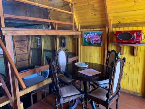 カラグアタトゥーバにあるChalé Caiçaraのダイニングルーム(テーブル、二段ベッド2組付)