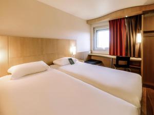 a bedroom with a large white bed and a desk at ibis Avignon Centre Gare in Avignon +138 photos
