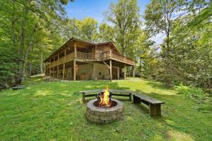 a log cabin with a fire pit in the yard at Natures Call in Boone