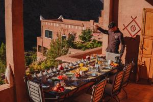 アジラルにあるAdaZen Ecolodgeの食卓の横に立つ男