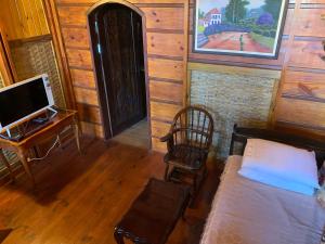 カラグアタトゥーバにあるChalé Caiçaraのベッドと机とテレビのある部屋