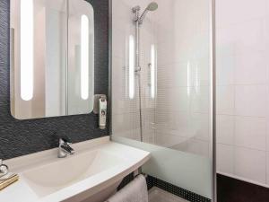 a white bathroom with a sink and a shower at ibis Thonon Centre in Thonon-les-Bains