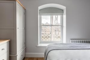 een slaapkamer met een bed en een raam bij Luxury Apartment Woodsmill View - on the river - with balcony - Recently refurbished in York