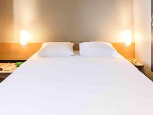 a large white bed with two pillows in a room at ibis Thonon Centre in Thonon-les-Bains +40 photos