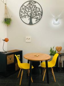 einen Tisch und Stühle in einem Zimmer mit einer Uhr an der Wand in der Unterkunft AdaBibas in Vermelho + 16 Fotos